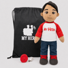A plush doll with a black beanie and a red-and-white shirt printed with 'MY HERO' stands next to a black drawstring bag with matching white text and a small red accessory on a light gray background.