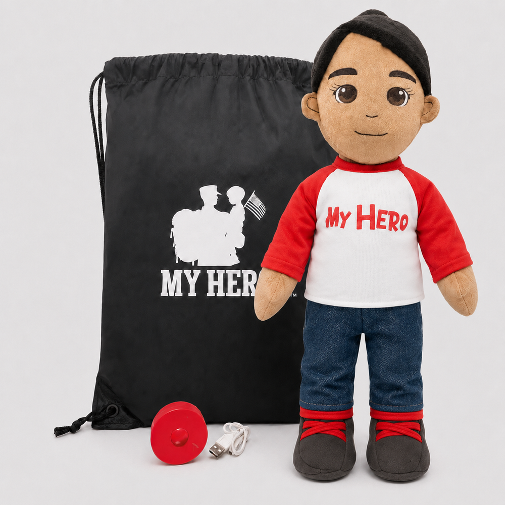 A plush doll with a black beanie and a red-and-white shirt printed with 'MY HERO' stands next to a black drawstring bag with matching white text and a small red accessory on a light gray background.