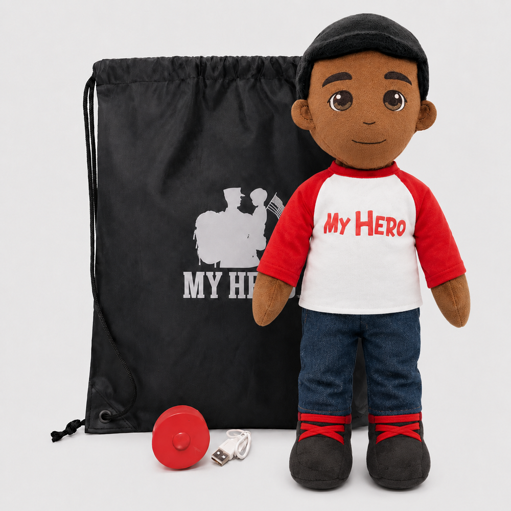 A plush doll toy stands in front of a black drawstring bag with a white 'MY HERO' graphic. The doll wears a black cap, a red-and-white raglan shirt with 'My Hero' in red text, blue jeans, and black shoes with red laces.