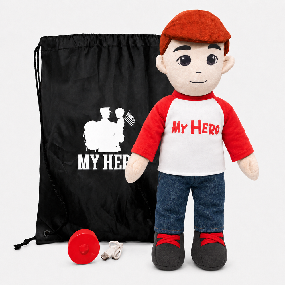 A plush toy soldier doll wearing a red beret, a red and white raglan shirt with 'My Hero' printed on it, blue jeans, and black shoes, standing next to a black drawstring bag with a white soldier graphic and matching text. A small red round accessory and a USB cable are placed in front on a light gray background.