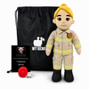 A firefighter-themed plush doll stands in front of a black drawstring bag with a white 'MY HERO' graphic, next to a small black card that reads 'UMBO. How are we doing? Feeling good, THANK YOU!' and a red fire hydrant, all on a white background.