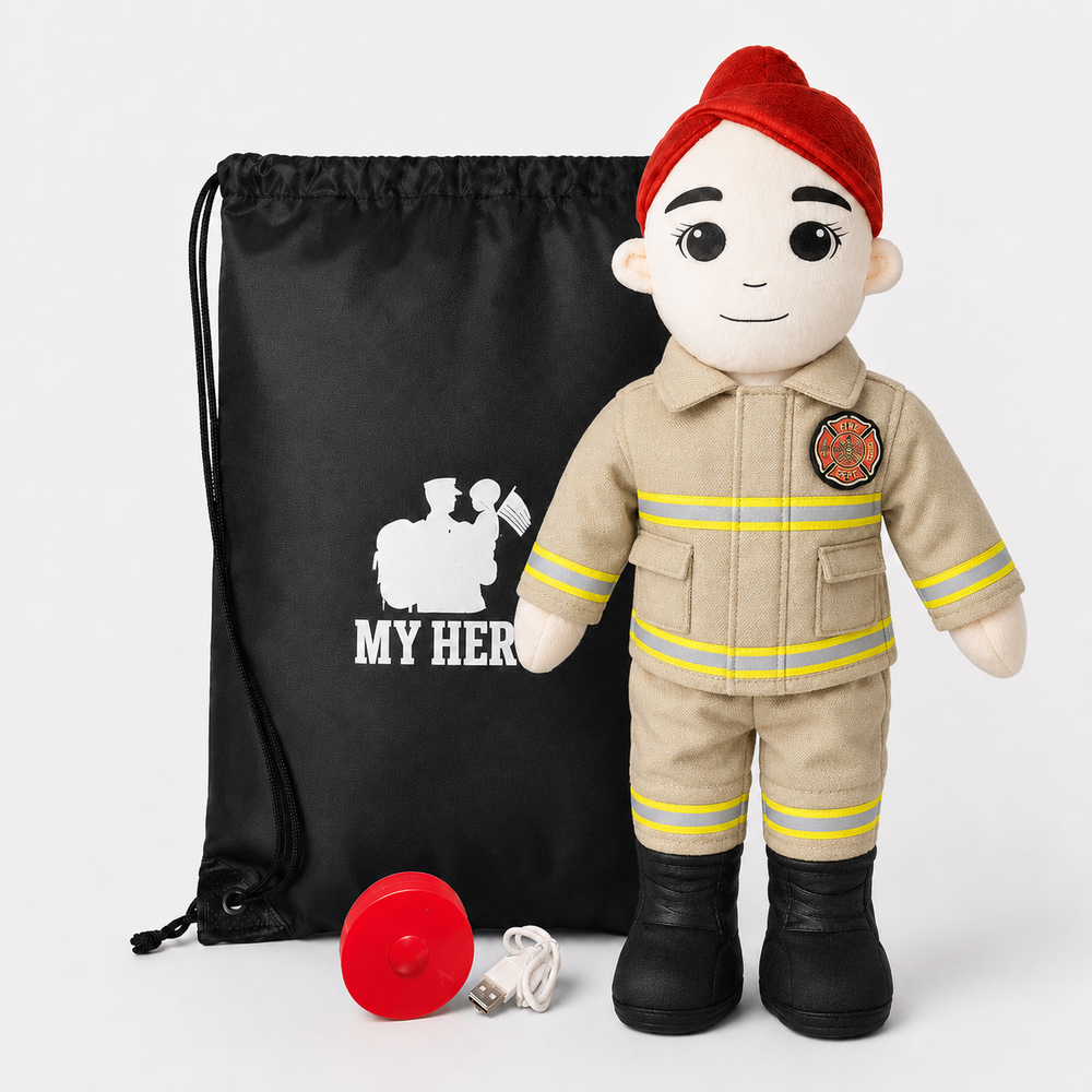 A firefighter-themed plush doll wearing a tan uniform, red beret, and black boots, standing in front of a black drawstring bag with a white firefighter silhouette and the words 'MY HERO'. A red helmet and a white USB charging cable are placed in front on a light gray background.