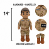 A hand-made soldier plush toy shown on a white background with text indicating 14 inches height, plus three circular detail insets showing the uniform, cap, and boot area. The text also says handmade, hand-filled and machine washable.