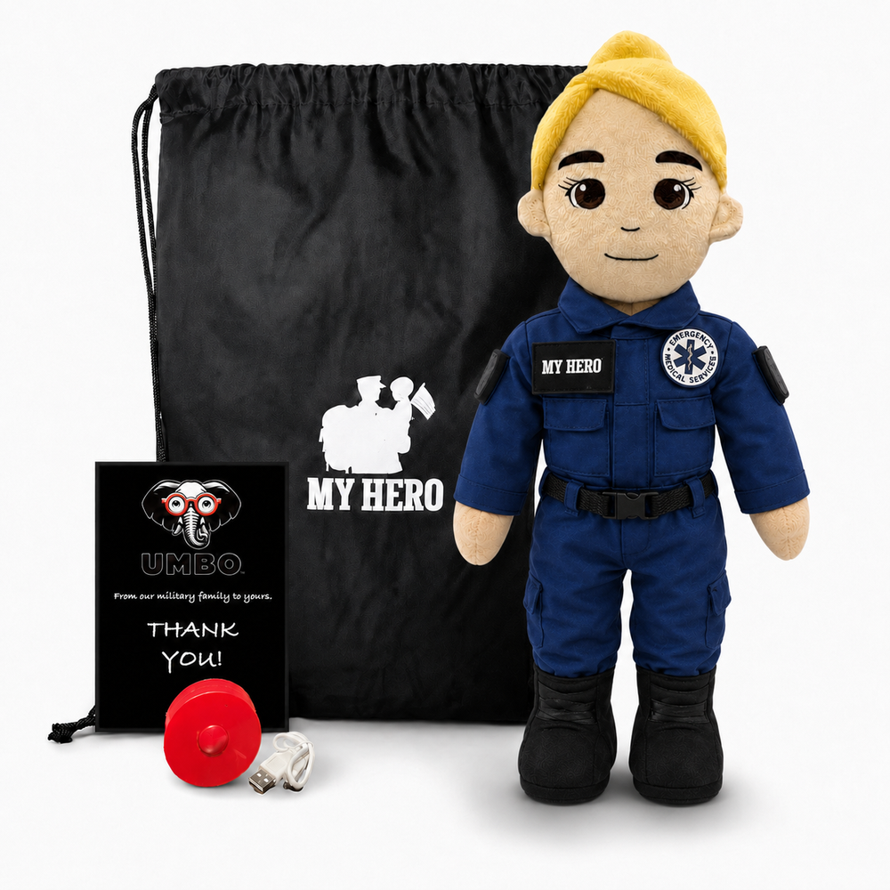 Paramedic Plush with fair skin and blonde hair, female EMT doll in a blue emergency responder uniform with black boots beside a black My Hero backpack, recorder and accessories on a white background.