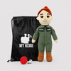 Pilot Doll Tan Skin Black Hair Female Doll with Flight Suit, My Hero Backpack, Recorder and Charger. standing beside a black drawstring bag printed with the words 'MY HERO' and a white silhouette. A small red circular item and a white cord are placed in front on a light gray studio background.