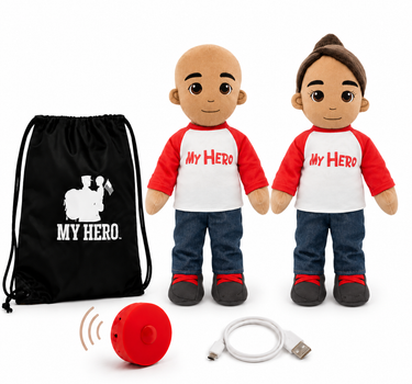 Two customizable plush toy dolls with realistic skin tones, wearing red and white raglan shirts with 'MY HERO' printed on the chest, blue jeans, and black shoes. The set includes a black drawstring bag with a white graphic, a red personal alarm, and a white USB charging cable, all on a white background.