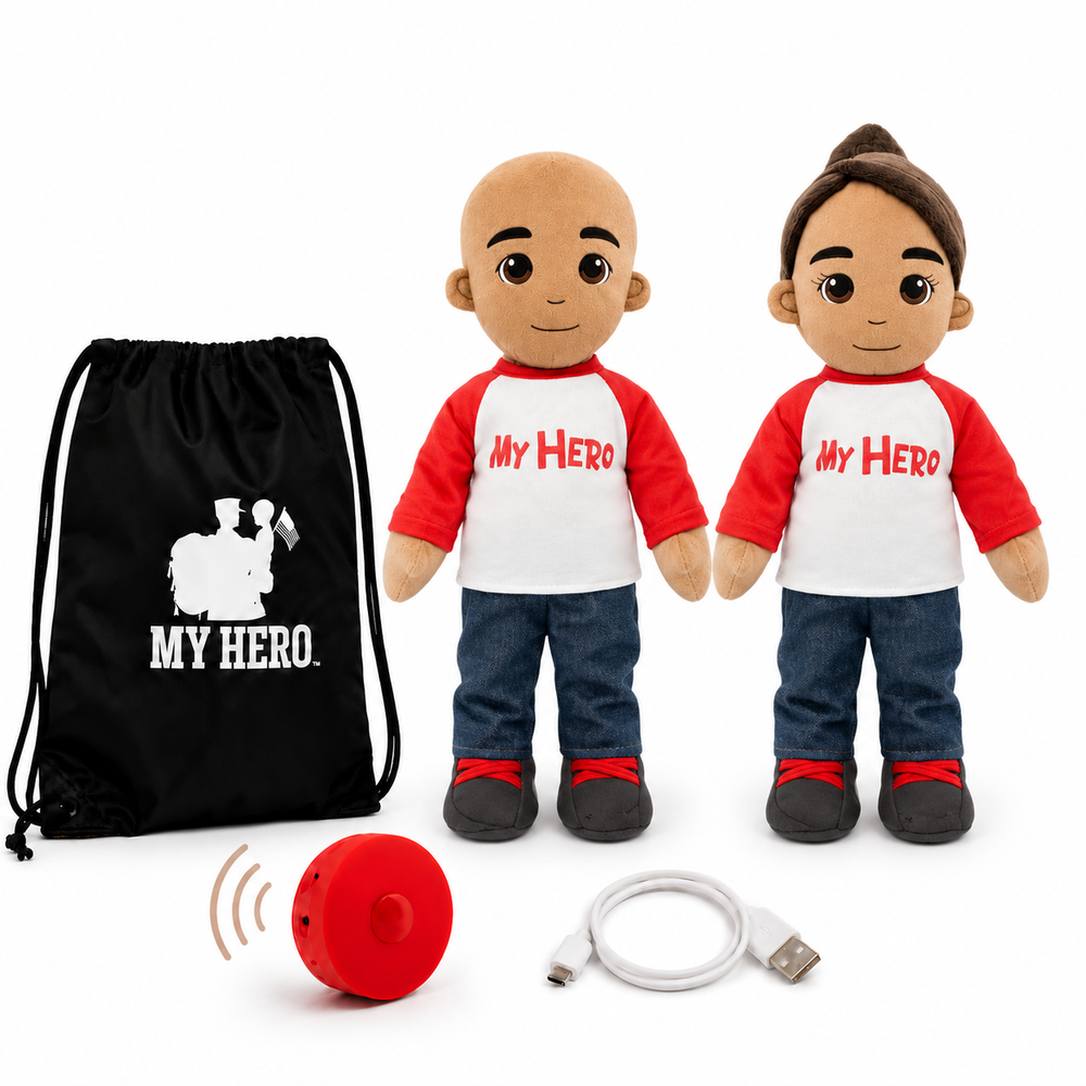 Two customizable plush toy dolls with realistic skin tones, wearing red and white raglan shirts with 'MY HERO' printed on the chest, blue jeans, and black shoes. The set includes a black drawstring bag with a white graphic, a red personal alarm, and a white USB charging cable, all on a white background.