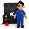 Doctor doll in blue medical scrubs with tan skin and black hair, female recordable healthcare dollA plush medical-themed doll stands in front of a black drawstring bag, with a small black card and a red circular accessory on a white studio background. The doll has dark hair, brown skin, and wears a blue scrub top and pants with black shoes and red accents.