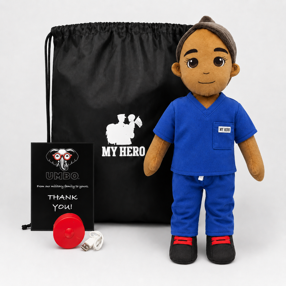A custom plush doctor doll in a blue scrubs set stands next to a black drawstring bag, a black gift card, and a small red USB charging cable on a light gray background. The doll and bag feature the printed text 'MY HERO' and a white medical cross graphic.