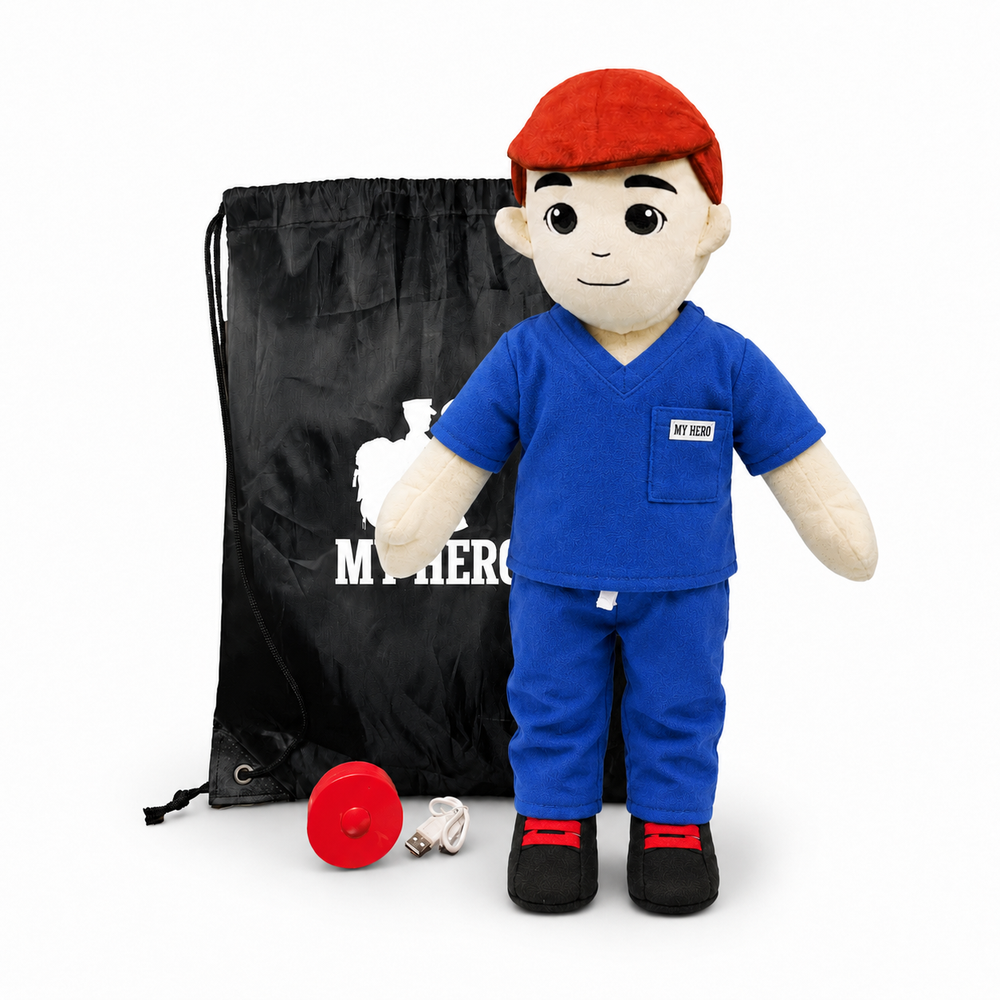 A plush medical training doll dressed in blue scrubs with a red cap, standing in front of a black drawstring bag with white text, with a red weight and small accessory on the floor, photographed on a white background.